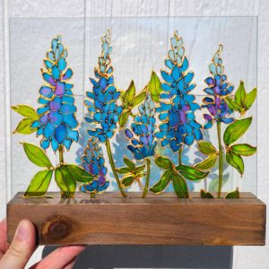 Hand holding a wooden pot with stained glass flowers