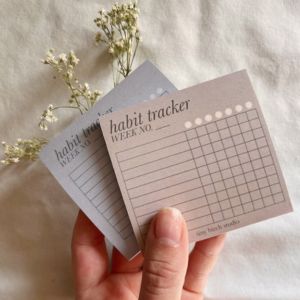 hand holding two habit tracker small notes