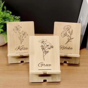 a womans writs with a pink keychain wallet on it