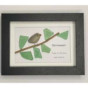 A photo frame that has a bird sitting ona branch made out of pebbles