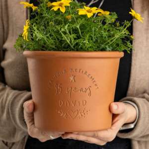 hands holding a brown planter