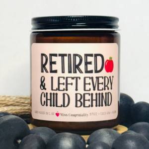 A brown amber glass jar soy candle with a cream label printed displayed on a textured surface