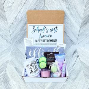 An open gift set containing products arranged on a light grey geometric background.