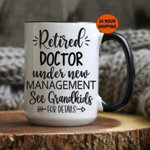 White mug reading retired doctor under new management see grandkids