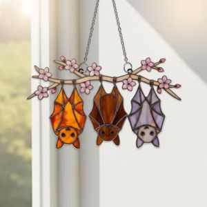 Suncatcher with Three bats hanging upside down on a window