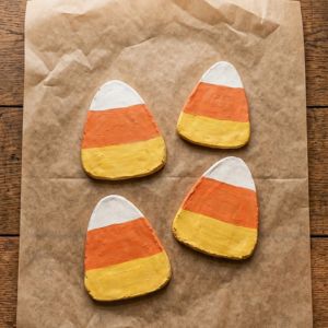 4 candy corn shaped clay coasters drying on a parchmant paper
