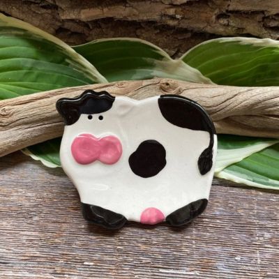 Black and white ceramic cow dish on wood surface