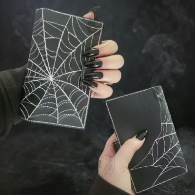 Black passport holder with white spiderweb stitching design