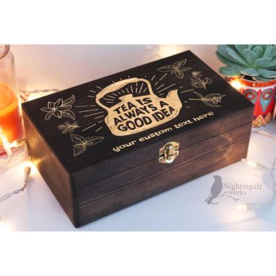 Dark wooden box with engraved lettering and string lights