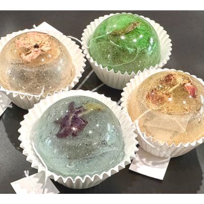 Four round tea bombs with dried flowers on top