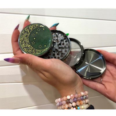 Green herb grinder with crescent moon and stars design