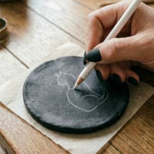 Gift-wrapped clay coasters beside a black cat mug and gift tag
