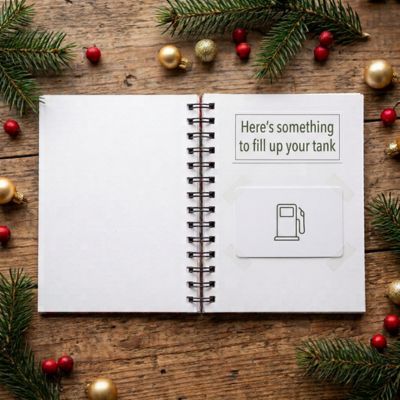 Open notebook page with a gas station gift card taped below a note about filling up a tank