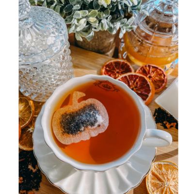 Pumpkin shaped tea bag steeping in a teacup