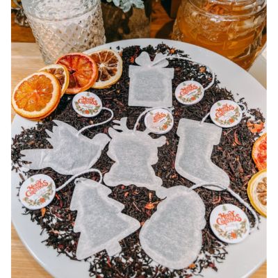 Shaped tea bags resting on loose black tea leaves