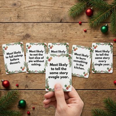 hand holding a card with 5 cards laid out on table in the back
