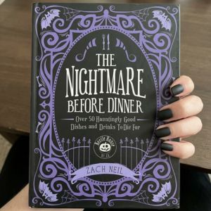 hand holding the nightmare before christmas cook book